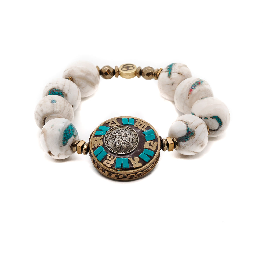 Embrace the spiritual energy of the Tibetan Mantra Bracelet, featuring Nepalese White beads with turquoise inlayed and a reversible Om Mani Padme Hum mantra disc bead.