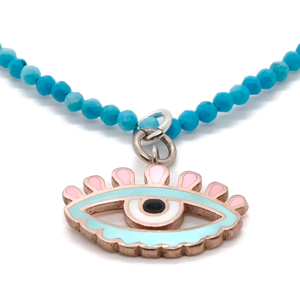 Necklace showcasing the striking combination of a silver Evil Eye charm and natural turquoise stone beads, creating a captivating design.
