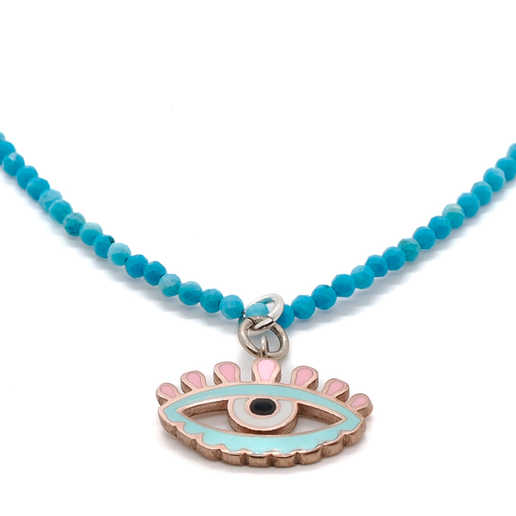 the Evil Eye charm, the necklace also features natural turquoise stone beads. The beads have been carefully selected for their unique color and texture, adding a touch of natural beauty to the piece.