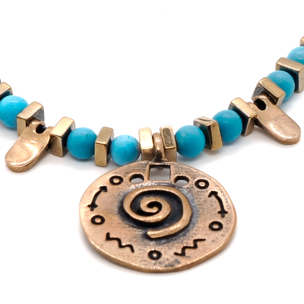 Close-up of the spiral charm on the Turquoise Spiral Necklace, emphasizing its delicate details and symbolism.
