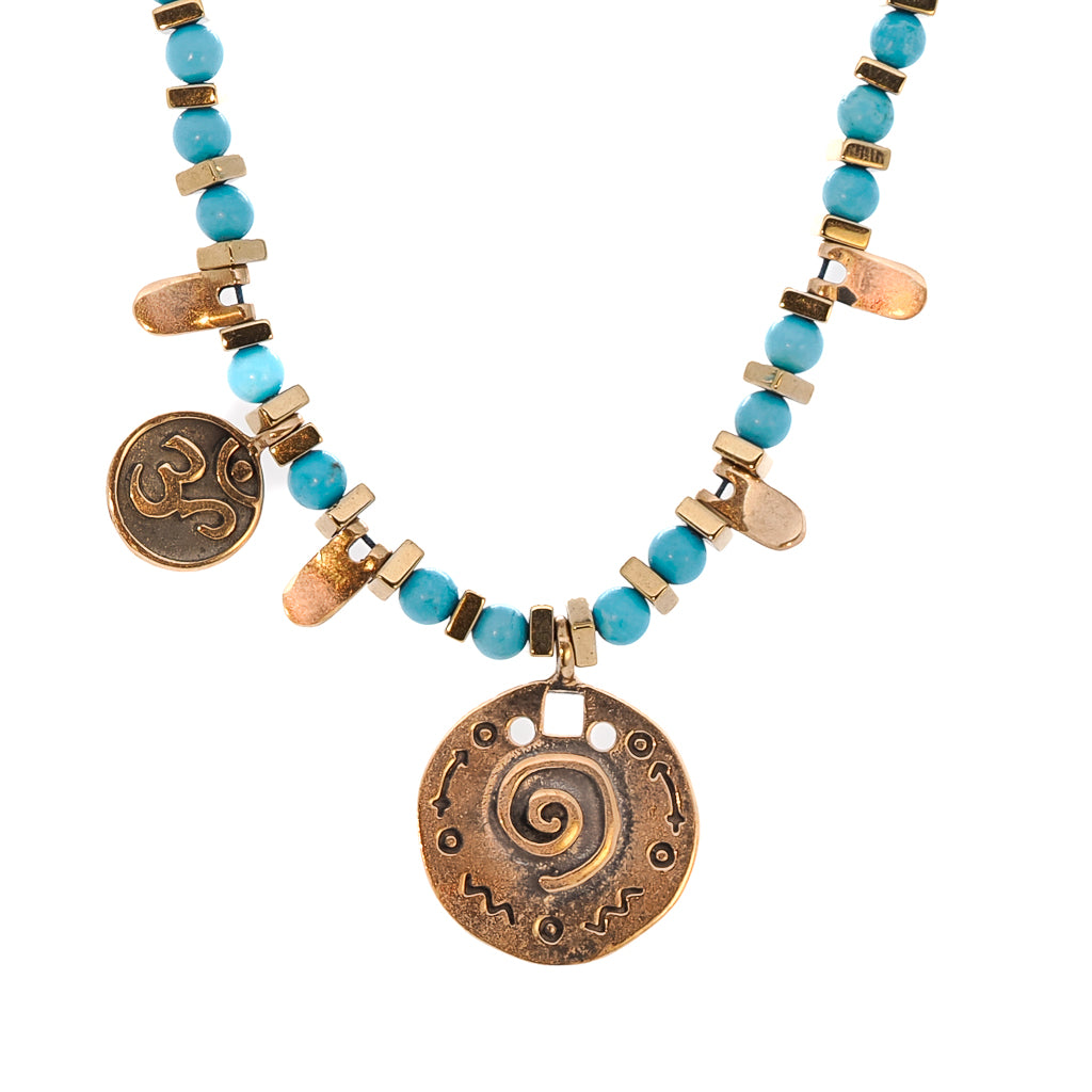 Elegant necklace adorned with turquoise and gold hematite stones, complemented by the OM mantra charm and spiral pendant.