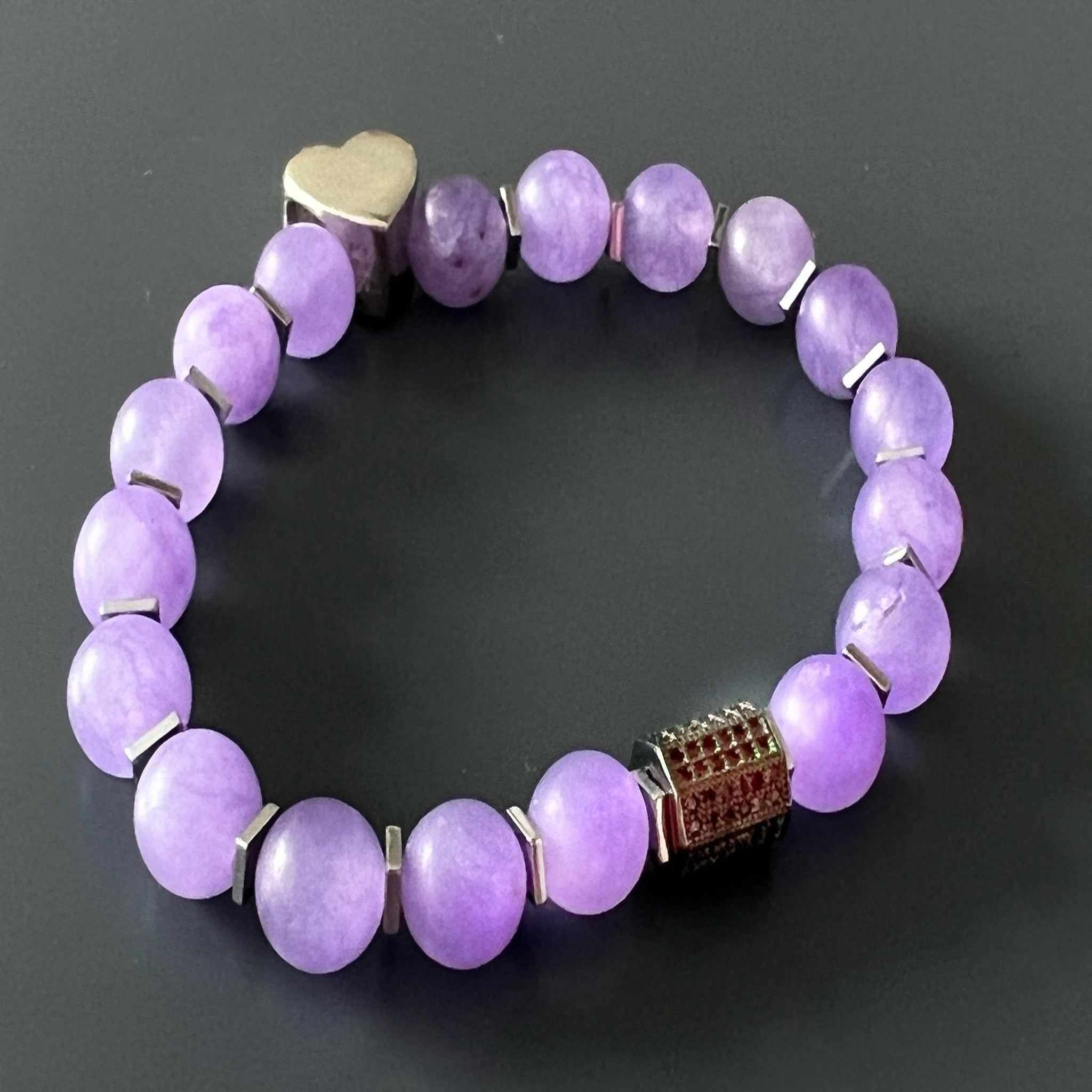 Add a touch of love and sophistication to your style with the Violet Love Bracelet, adorned with purple jade beads, sterling silver heart charms, and a glistening Swarovski crystal accent.