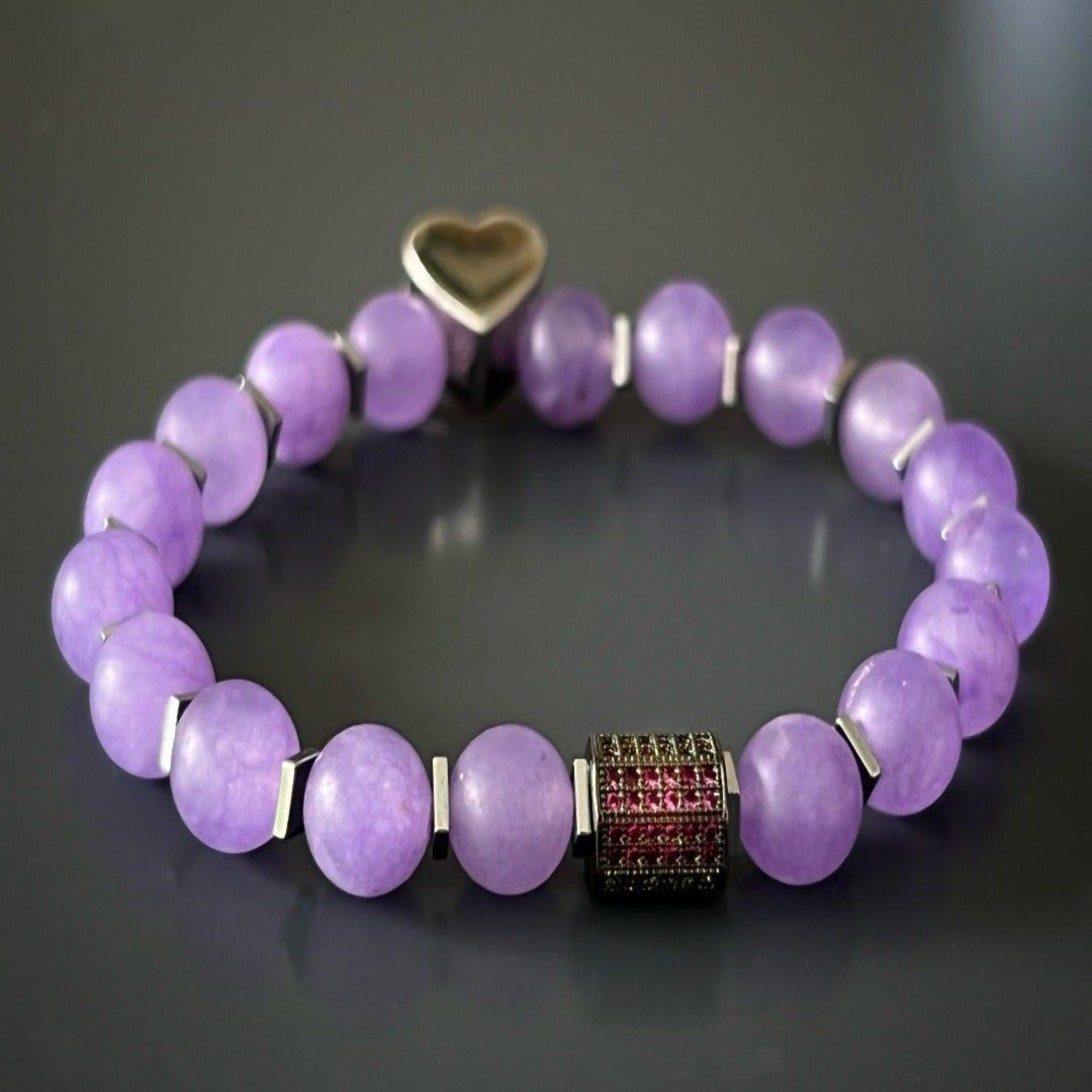 The Violet Love Bracelet symbolizes love, healing, and sophistication, with its combination of purple jade beads, sterling silver heart charms, and a dazzling Swarovski crystal accent.