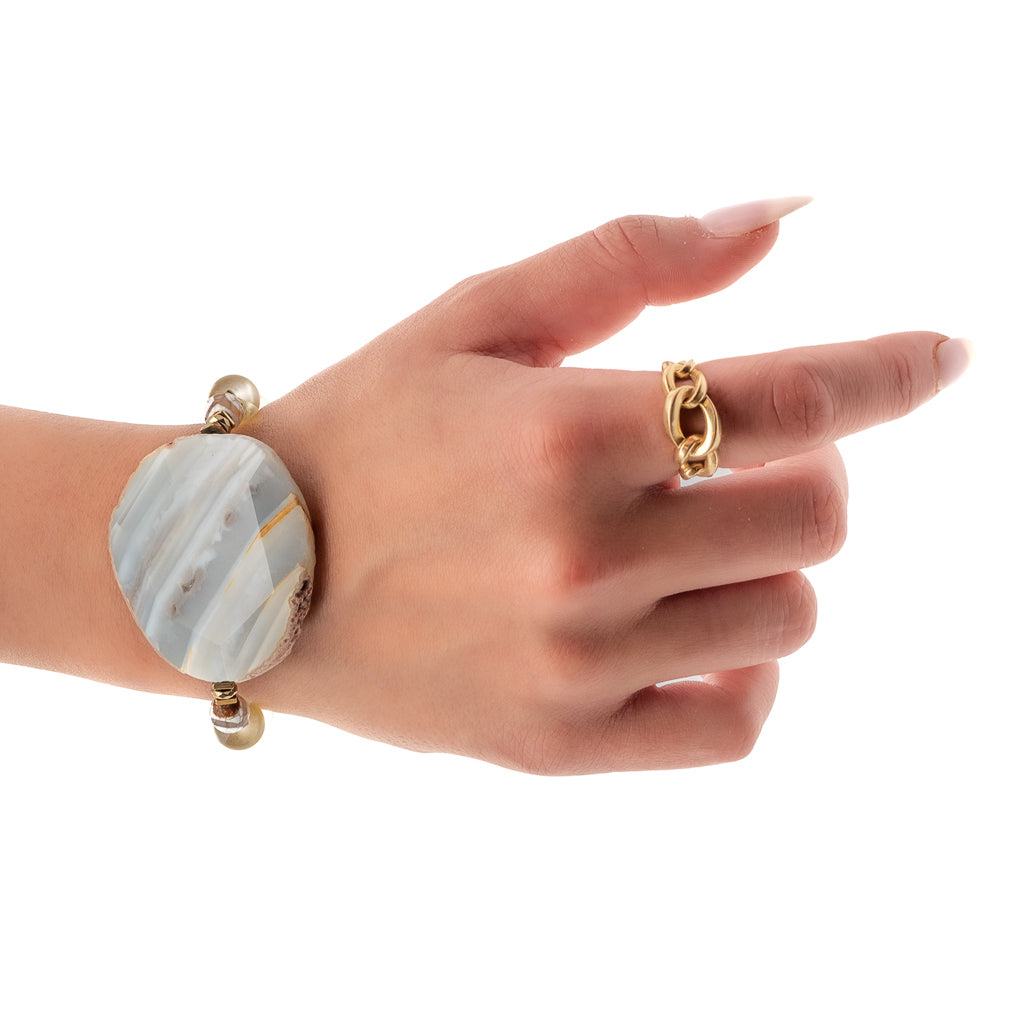 See how the Yellow Chunky Agate Bracelet enhances the hand model&#39;s style, with its shimmering cat eye beads and large Agate stone.