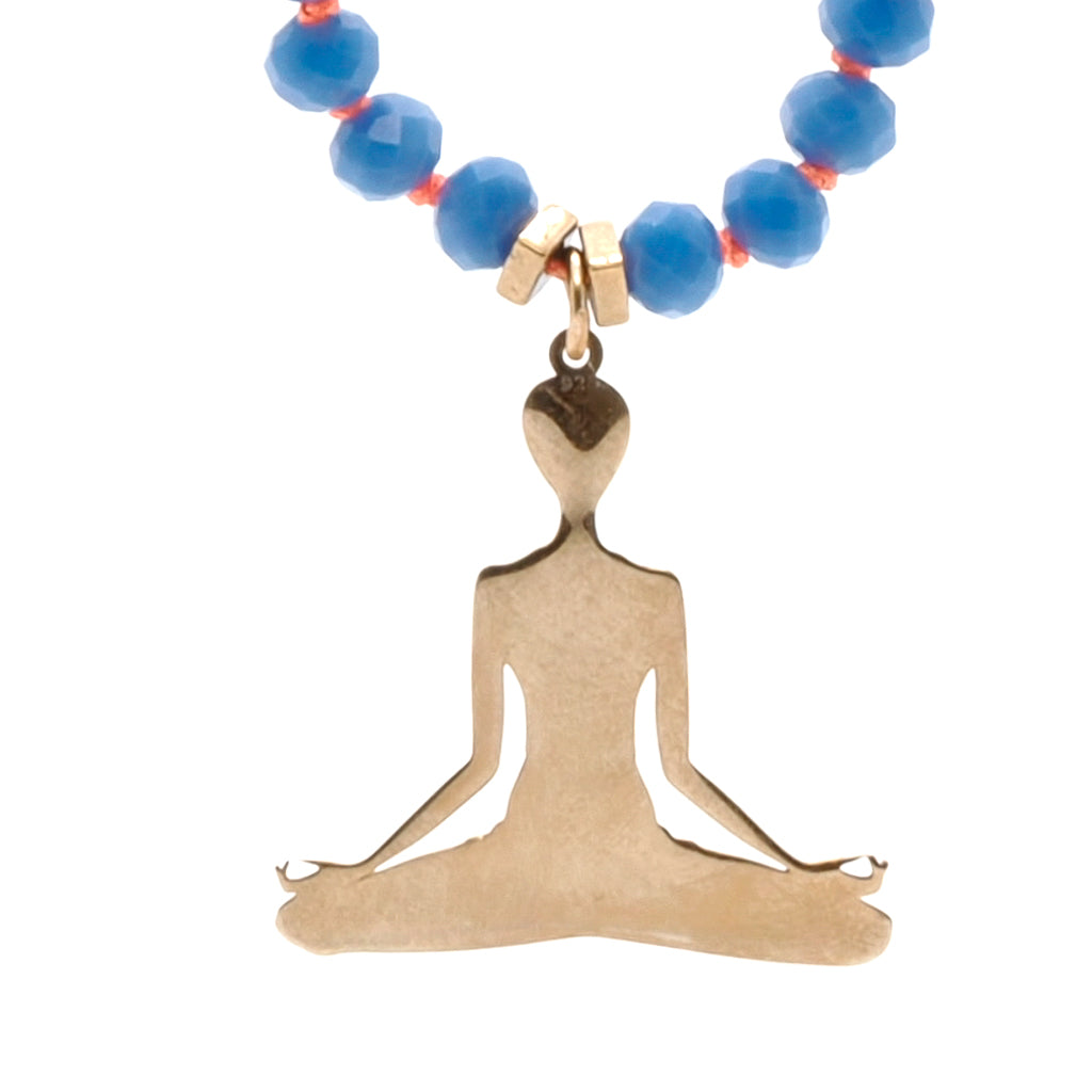 Necklace adorned with blue crystal beads, gold hematite spacers, and a Nepal Om Mani Padme Hum mantra bead, perfect for promoting relaxation and mindfulness.