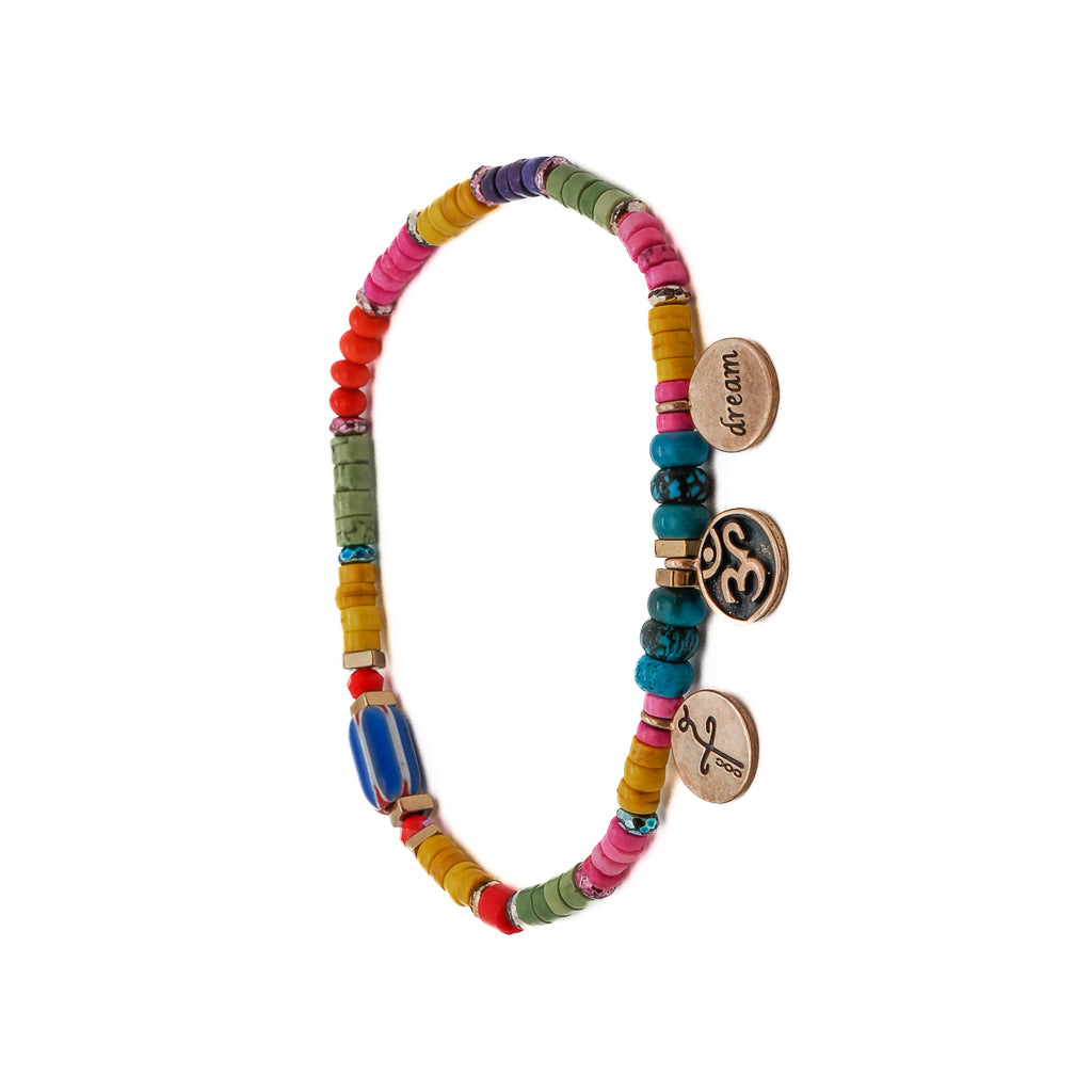 Discover the power of dreams and healing with the Yogi Dream Anklet, featuring bronze gold-plated Om-Dream and Heal charms, turquoise stone beads, and African blue beads, a beautiful expression of your spiritual journey.