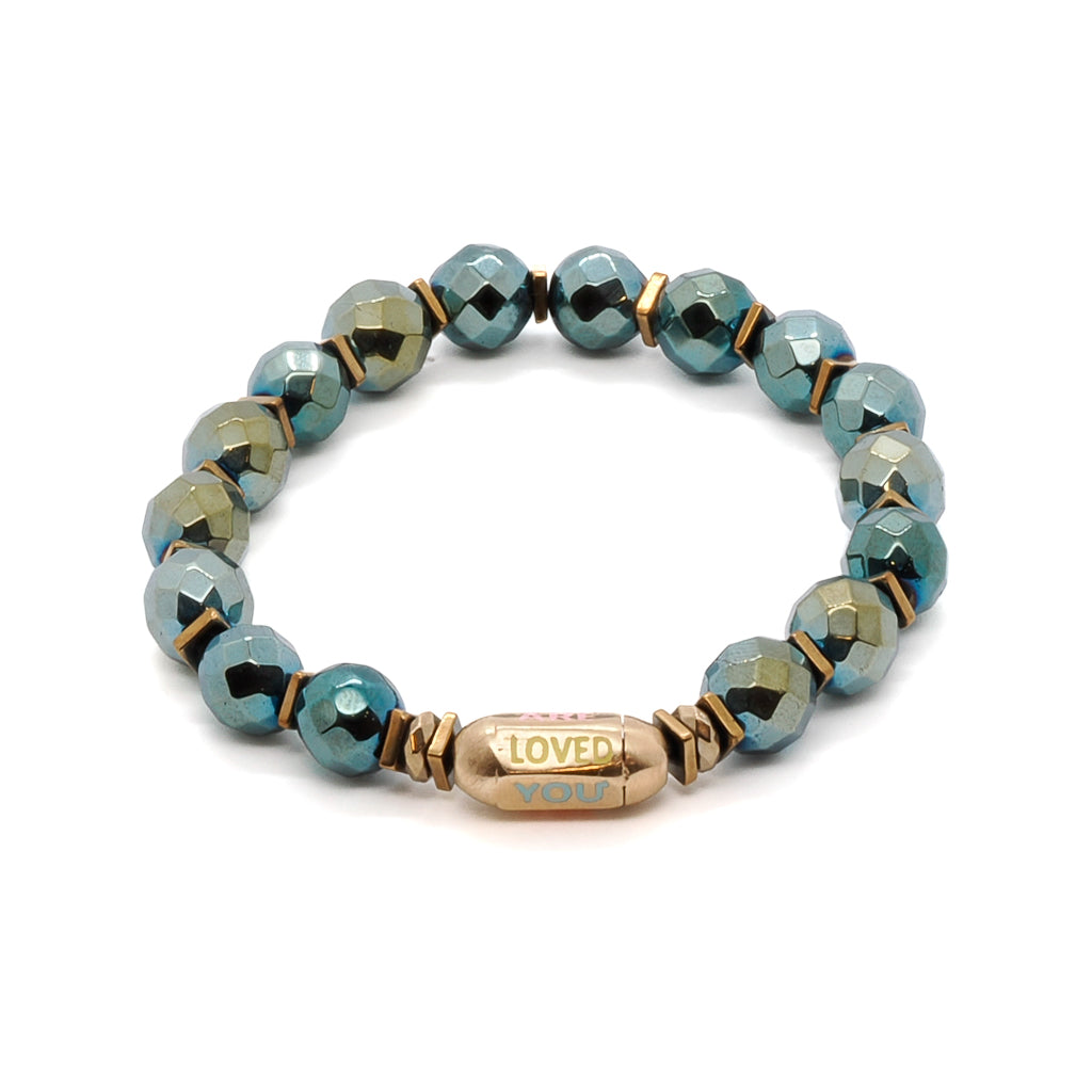 Embrace the love and support around you with the You Are Loved Bracelet, featuring green hematite stone beads and a beautiful "You Are Loved" tube bead.